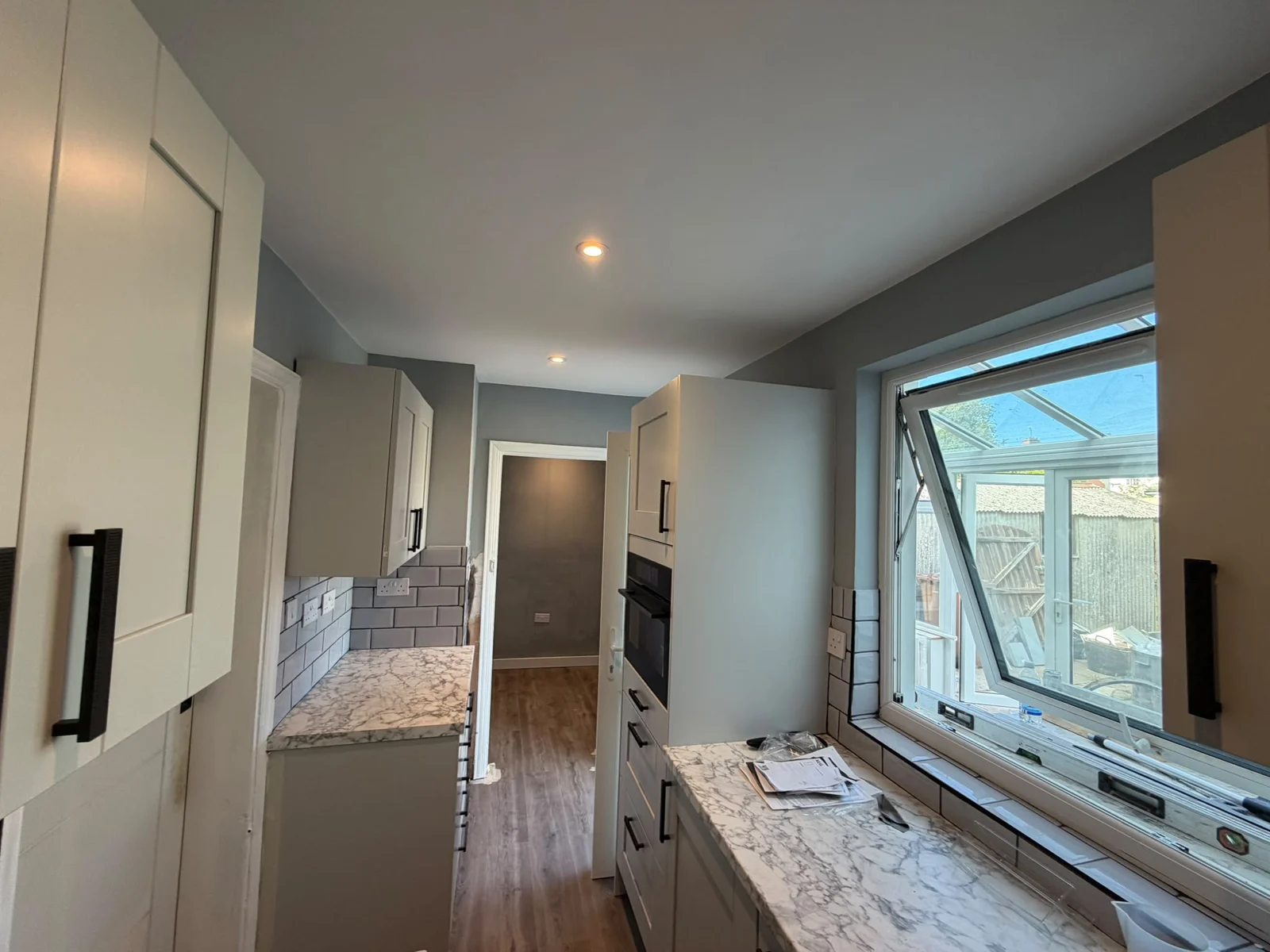 Long view of a galley kitchen towards the window — RV Renovation, Oxford