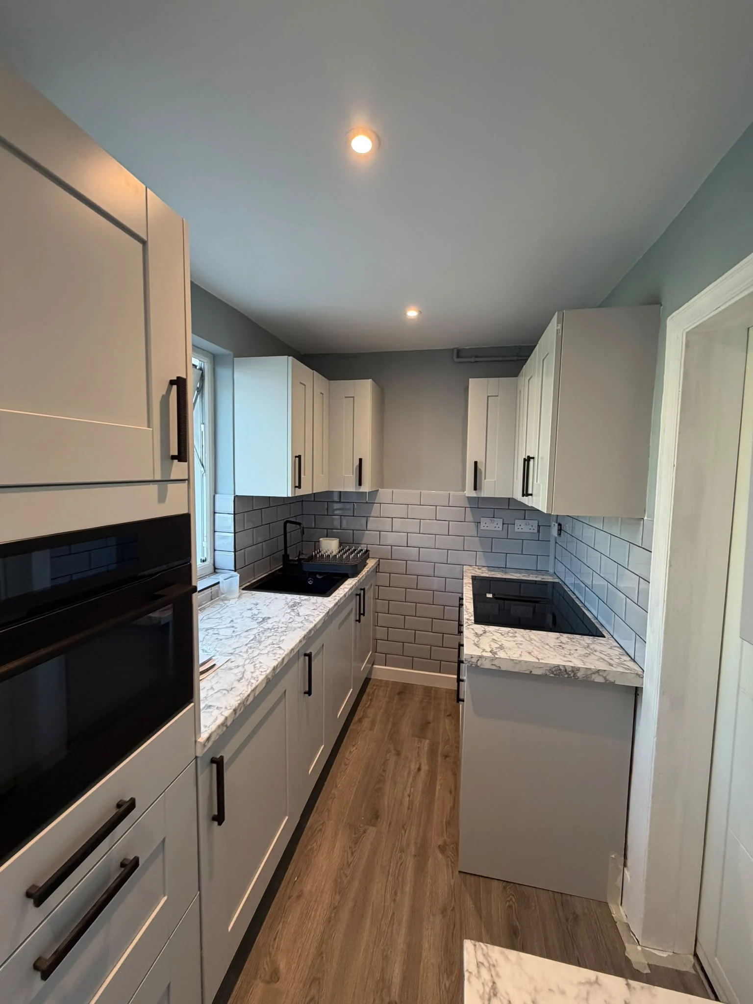 Galley shaker kitchen with marble-effect worktops and metro tiles — RV Renovation, Oxford