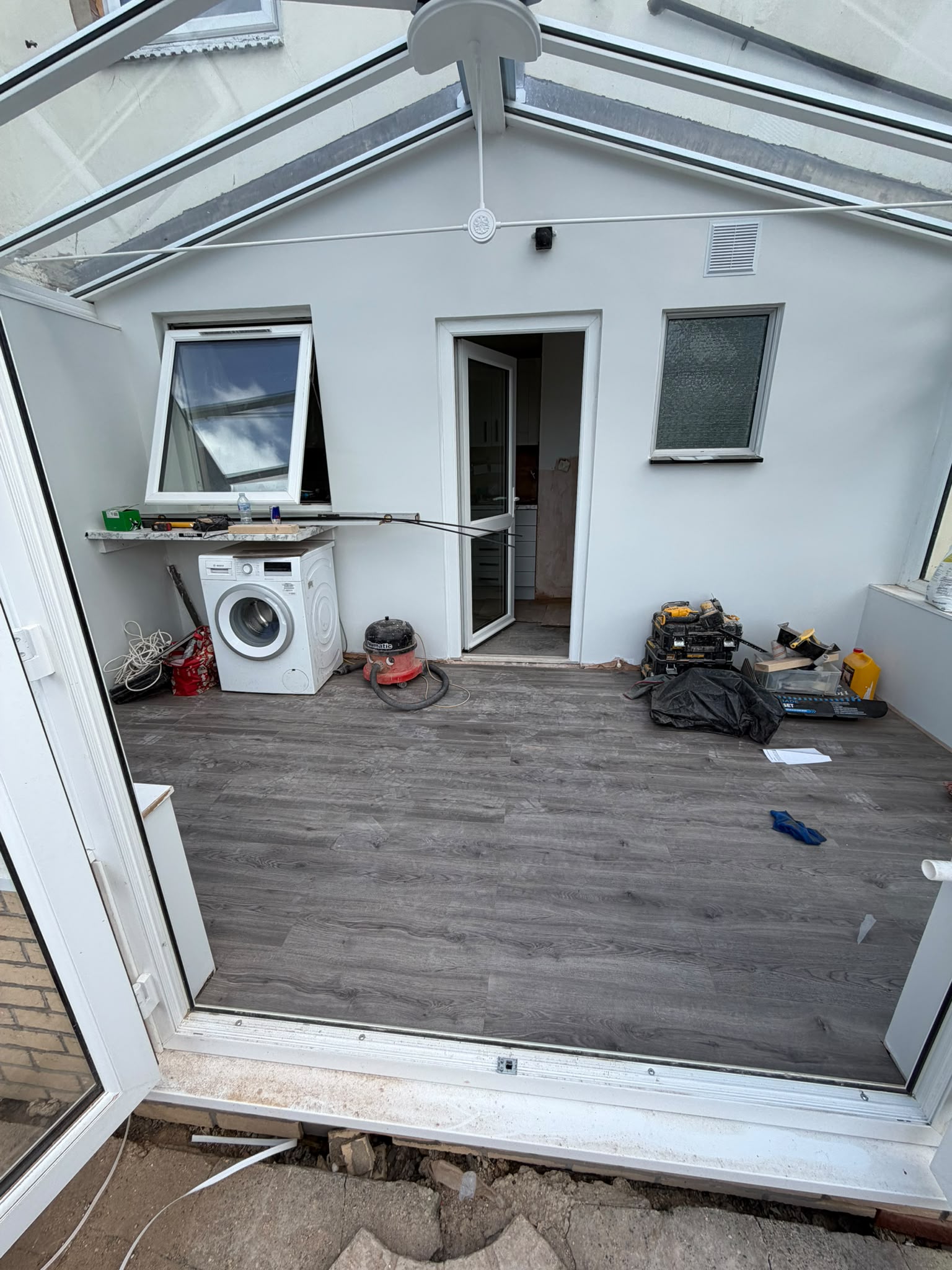 Grey wood-effect vinyl plank floor laid in a conservatory, RV Renovation, Oxford
