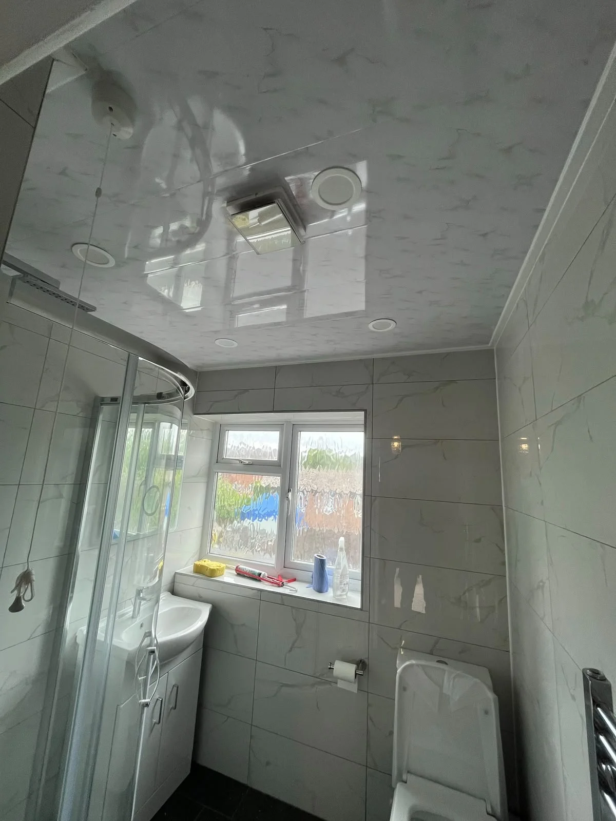 Corner shower enclosure beneath a glossy ceiling with spotlights — RV Renovation, Oxford