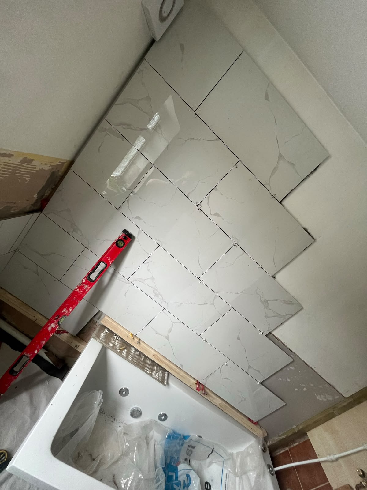 Diagonal marble-effect wall tiles set out with a spirit level, RV Renovation, Oxford